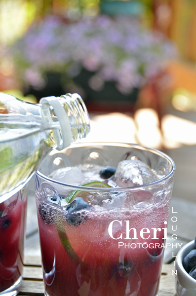 Blueberry Peach Mojito Adding Club Soda Topper 090: Outdoor Entertaining set-up for Driscolls Blueberry Peach Mojito cocktail recipe  Cheri Loughlin is The Intoxicologist, a corporate mixologist who creates and photographs the best cocktails and mixed drinks for home entertaining and bar use.