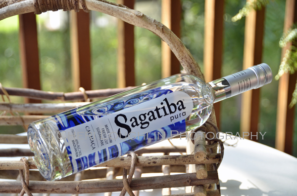 Sagatiba Cachaca Bottle 018 shown on side laying on basket. - photo by Mixologist Cheri Loughlin, The Intoxicologist